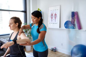 Female physiotherapist treating a female patient in a bright office