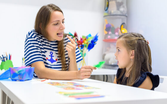 Female Speech Therapist teaching a young female patient pronunciation